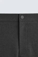 Pantalón de corte slim fit confeccionado en tejido elástico, con cintura elástica, cierre frontal con cremallera y botón, bolsillos laterales y bolsillos traseros de vivo.