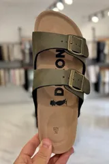 Sandalia marrón con diseño de dos tiras ajustables con hebillas metálicas y plantilla anatómica.