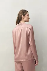 Camisa de pijama color verde menta, de silueta clásica y tacto sedoso. Confeccionada en tejido satinado con leve elasticidad, presenta cuello camisero, cierre frontal con botones y detalles de vivo blanco que realzan el diseño.