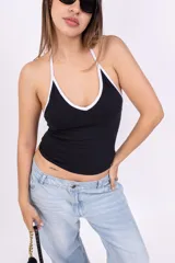 Top negro con tirantes finos blancos y escote halter.