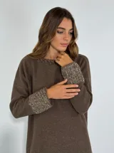 Sweater marrón de cuello redondo con detalle de volados en el borde y puños de punto grueso en contraste.