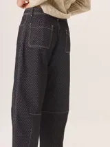 Pantalón de corte barrel en tejido de pana con estampado geométrico sutil y costuras a la vista. Presenta tiro medio, cierre frontal con botón y bolsillos laterales.