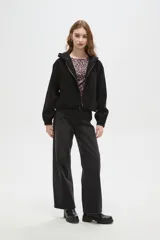 Campera de textura aterciopelada con cierre frontal completo, capucha y puños elásticos.