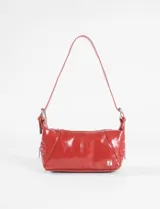 Cartera de hombro de diseño rectangular, confeccionada en material sintético con acabado brillante. Presenta costuras decorativas verticales y cierre metálico en el compartimento principal. Incluye una correa fija con detalles de ojalillos metálicos.