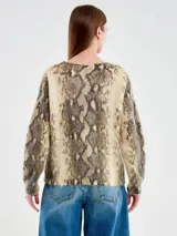 Sweater tejido de punto con estampado animal print de serpiente en tonos beige y gris. Posee cuello redondo amplio, mangas largas y un calce holgado. Está confeccionado en una mezcla de lana, acrílico y nylon.