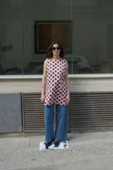 Vestido corto sin mangas, color rosa pálido con estampado de lunares marrones.