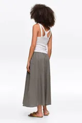 Falda midi de corte en línea A color negro con diseño de cuadros vichy blancos y negros, con bolsillos laterales y cintura elástica.