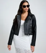 Campera biker de poliuretano color marrón oscuro, con cuello con solapas, cierre frontal de cremallera metálica, bolsillos laterales con cierre y detalles de botones a presión.