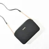 Bandolera negra con correa de cadena dorada y tira de cuero sintético.