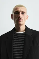 Blazer de corte relajado confeccionada en tejido fluido con mezcla de viscosa. Presenta cuello con solapas de muesca, manga larga con puños abotonados, bolsillos de solapa en la cadera y cierre frontal con botones.