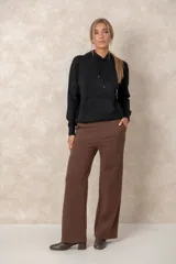 Buzo de punto negro con capucha, cordones ajustables con terminales metálicos, mangas raglán y bolsillo tipo canguro frontal.