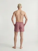 Short de baño rojo con estampado geométrico, cintura elástica con cordón de ajuste naranja y bolsillos delanteros.