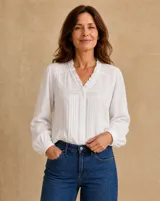 Camisa blanca de manga larga con detalles de encaje, pliegues frontales y cuello con volados.