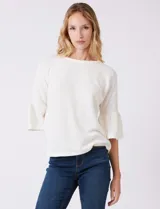 Buzo tejido de punto fino color blanco, con cuello redondo y mangas tres cuartos con terminación acampanada.