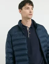 Campera capitoneada de poliéster con cierre frontal al tono y bolsillos laterales con cierre invisible.