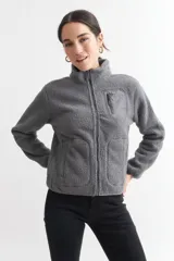 Campera negra de corderito con cuello alto, cierre frontal con cremallera, bolsillo de parche en el pecho y bolsillos laterales.