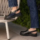 Sueco de cuero vacuno color marrón con estampado de cocodrilo, suela de goma negra y hebilla metálica plateada.