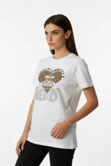 Remera de algodón color negro con cuello redondo y mangas cortas. Presenta un estampado frontal con diseño de rosas, rayos y texto, decorado con detalles de strass.