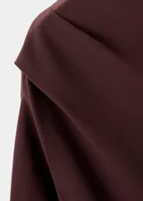 Blusa de manga larga color bordó con cuello asimétrico y detalle fruncido en el hombro. Presenta un diseño entallado al cuerpo.