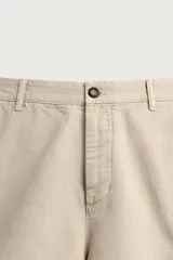Bermuda cargo regular fit color beige, confeccionada en mezcla de algodón y lino con efecto lavado. Cuenta con bolsillos laterales tipo cargo con solapa en las perneras, bolsillos frontales, cierre frontal con cremallera y botón, y presillas para cinturón.