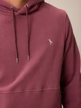 Canguro de polar azul con capucha y cordones ajustables. Presenta un bolsillo frontal tipo canguro y un pequeño logo bordado en el pecho.