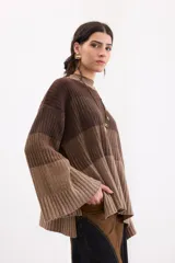 Sweater de punto con diseño en bloques de tonos marrones y tostados, cuello redondo y mangas largas amplias.