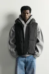 Chaleco acolchado puffer color negro para hombre, de corte regular fit, con capucha ajustable, cierre frontal de cremallera y bolsillos laterales de vivo.