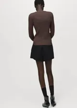 Cardigan de punto fino con diseño recto y textura de canalé. Presenta cuello de pico, cierre frontal con botones y mangas largas.