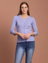 Cardigan blanco de tejido fino con abertura central y botones.