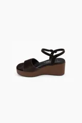 Sandalias de plataforma con cuña efecto madera y capellada de gamuza negra, con tira ancha en la parte delantera y tira ajustable alrededor del tobillo.