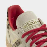 Championes Adidas modelo Handball Spezial, con diseño clásico de perfil bajo. Presentan una base en tono beige con detalles de estampado animal print en las icónicas tres tiras laterales y en el talón. Incluyen cordones en color rojo vibrante, forro interior a tono y suela de caucho tipo goma.