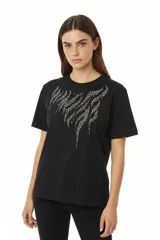 Remera de algodón negra, manga corta y cuello redondo, con un diseño abstracto de líneas curvas formadas por apliques de studs plateados en el pecho.