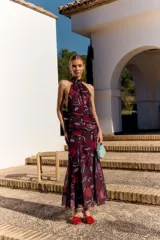Vestido midi bordó de Lady Pipa, con estampado floral en tonos rojos y celestes, cuello halter fruncido, diseño sin mangas con espalda descubierta y detalle fruncido en la cintura y cadera.