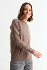 Sweater de punto fino en color verde menta, con cuello redondo, mangas largas y puños acanalados con detalle de botones metálicos laterales.