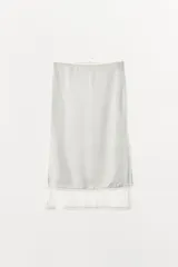 Falda midi de tiro medio, color blanco, confeccionada en hilatura de viscosa 100%, con detalle de aplicación de tejido combinado semitransparente con abertura en el bajo y cierre lateral con cremallera oculta.