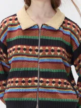 Campera de punto con cierre frontal, diseño de rayas horizontales multicolores y estampado geométrico. Presenta cuello de corderito y puños tejidos.