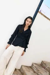 Camisa blanca de algodón con diseño cruzado y mangas largas con volados.