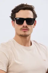 Lentes de sol polarizados con armazón rectangular de acetato negro y cristales oscuros.
