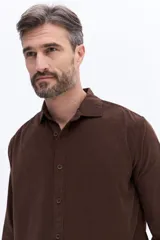 Camisa de pana de algodón con cuello clásico, cierre frontal de botones y mangas largas. Presenta un diseño de corte regular con textura suave y acabado mate.
