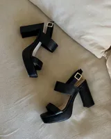 Sandalias de plataforma color marrón, con dos tiras anchas en el empeine y tobillo con hebilla dorada.