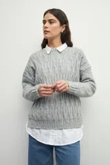 Sweater de tejido tramado en color verde oliva, con cuello redondo y mangas largas. Presenta un diseño de textura acanalada vertical.