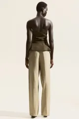 Top strapless color verde militar, con peplum y detalle de reborde de silicona en el escote.