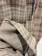 Pantalón tipo balloon de tejido plano con calce relajado, cintura elastizada y estampado cuadrillé en tonos marrones y beige.