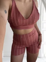 Conjunto de top y short color rosado con rayas verticales blancas. El top es de corte cropped y el short es ajustado.