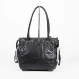 Cartera de cuero color negro, de diseño estructurado con doble asa de hombro, costuras decorativas contrastantes y detalles de flecos colgantes en los laterales.