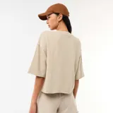 Camiseta de felpa color beige, de corte oversize, con mangas 3/4 y cuello redondo.