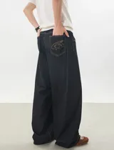 Jeans baggy de denim color azul oscuro, de corte ancho y relajado, con cintura semi-elástica en la parte trasera. Presenta bolsillos traseros con costuras a contratono y bordado de estrella en uno de ellos.