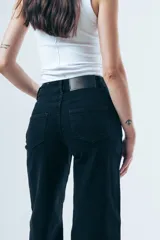 Jeans de denim negro de tiro alto y corte wide leg, con diseño de pernera ancha.