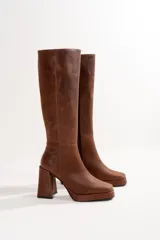Bota de cuero color marrón con caña alta, taco cuadrado y plataforma.