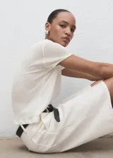 Camiseta blanca de manga corta y cuello redondo, de corte recto y diseño combinado con mezcla de poliéster y algodón.